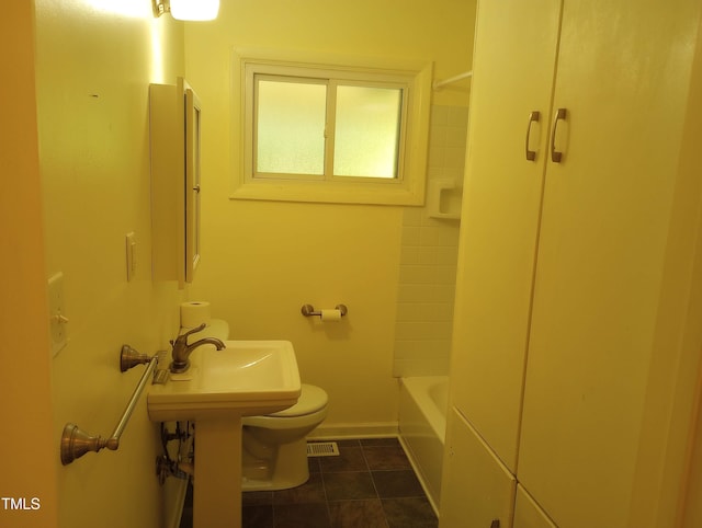 912 Dixie Trl, Raleigh, NC 27607 - bathroom featuring toilet, baseboards, tile patterned floors, and washtub / shower combination