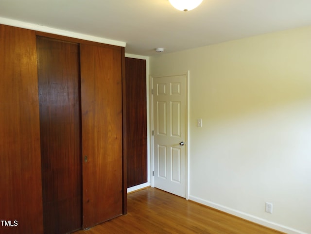 912 Dixie Trl, Raleigh, NC 27607 - unfurnished bedroom with a closet, wood finished floors, and baseboards