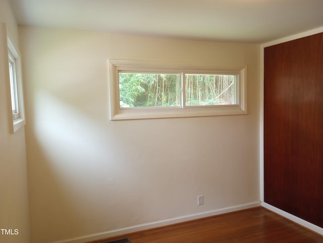 912 Dixie Trl, Raleigh, NC 27607 - unfurnished bedroom featuring multiple windows, wood finished floors, baseboards, and a closet