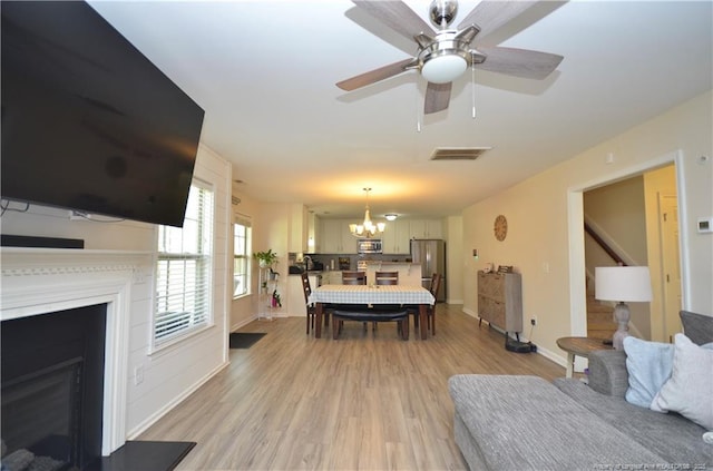 109 Red Coat Dr, Cameron, NC 28326 - living area featuring a fireplace, a chandelier, light wood-style flooring, a ceiling fan, and baseboards