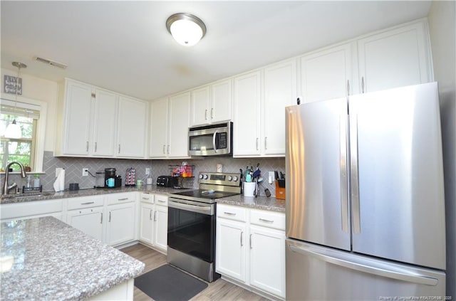 109 Red Coat Dr, Cameron, NC 28326 - kitchen with appliances with stainless steel finishes, a sink, white cabinets, and decorative backsplash