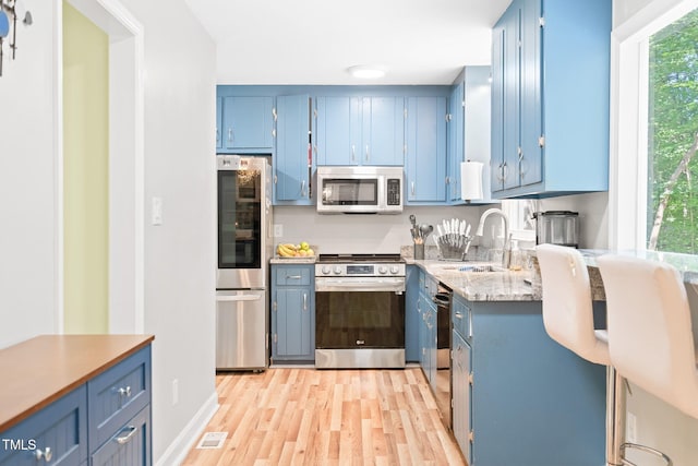 114 Bonaparte Dr, Hillsborough, NC 27278 - kitchen featuring stainless steel appliances, blue cabinetry, and a sink