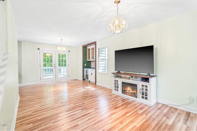 114 Bonaparte Dr, Hillsborough, NC 27278 - unfurnished living room featuring a chandelier, wood finished floors, baseboards, a glass covered fireplace, and wine cooler