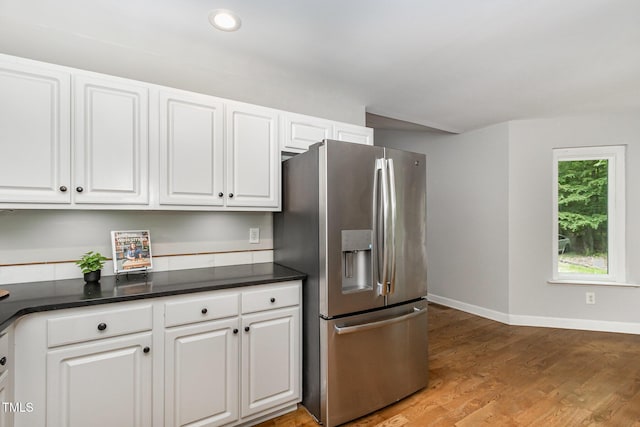 2805 Evans St, Durham, NC 27705 - kitchen featuring stainless steel fridge, white cabinets, dark countertops, baseboards, and light wood-type flooring