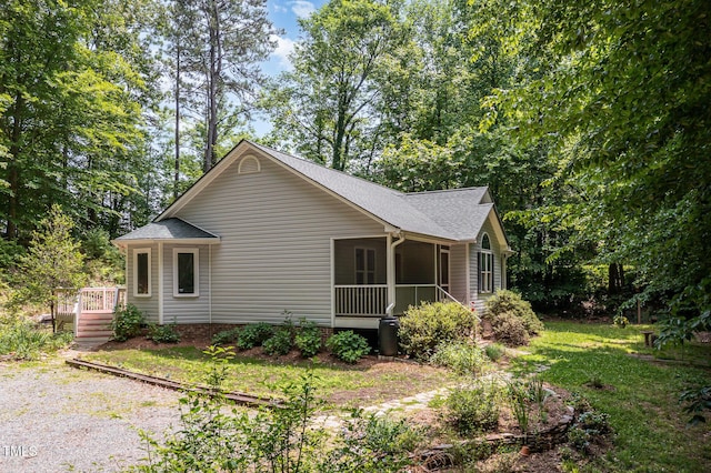 2805 Evans St, Durham, NC 27705 - view of home's exterior featuring a sunroom, roof with shingles, and a lawn