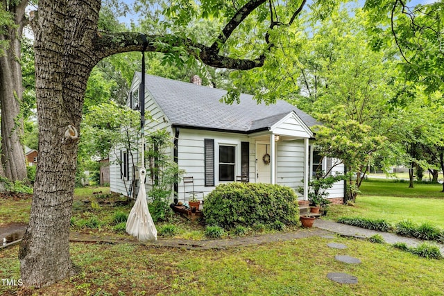 1105 Hawthorne Ln, Burlington, NC 27215 - view of front of house featuring a front lawn, a shingled roof, and a chimney