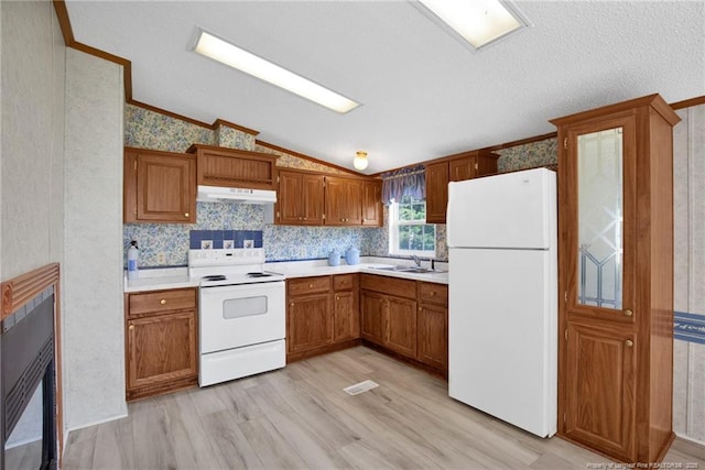 6131 Twiggs Ct, Hope Mills, NC 28348 - kitchen with white appliances, under cabinet range hood, vaulted ceiling, wallpapered walls, and light wood-style floors