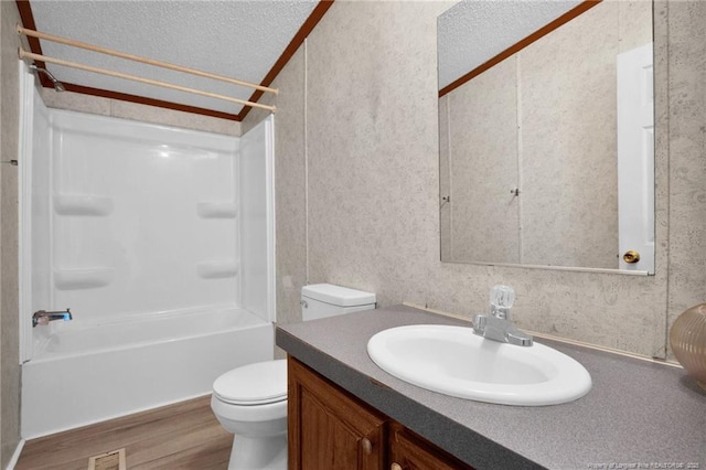 6131 Twiggs Ct, Hope Mills, NC 28348 - bathroom featuring a textured ceiling, toilet, wood finished floors, vanity, and tub / shower combination