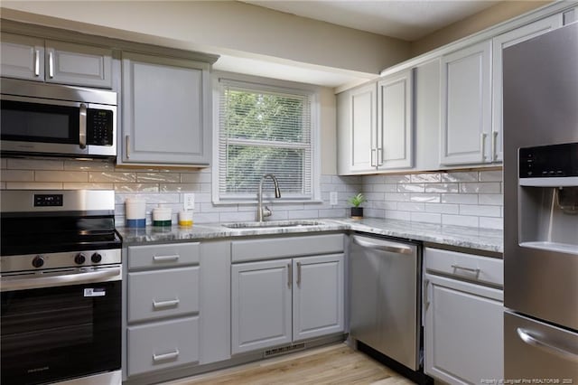 408 Harril Cir, Spring Lake, NC 28390 - kitchen with appliances with stainless steel finishes, a sink, decorative backsplash, and light stone countertops