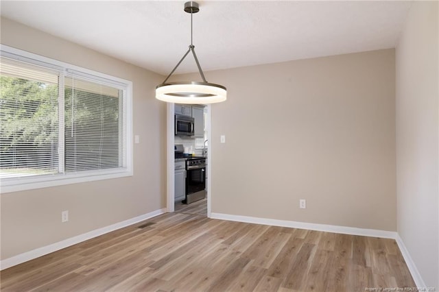 408 Harril Cir, Spring Lake, NC 28390 - spare room featuring light wood-style floors, baseboards, and a chandelier