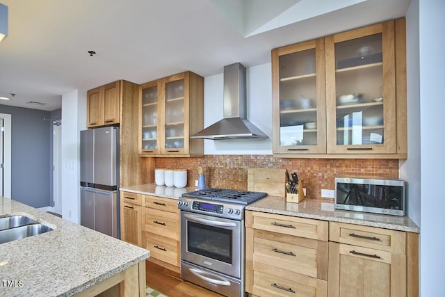 601 W Rosemary St Unit 416, Chapel Hill, NC 27516 - kitchen featuring wall chimney range hood, appliances with stainless steel finishes, light stone counters, and decorative backsplash