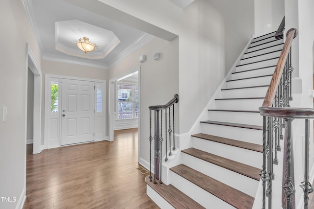 805 Alden Bridge Dr, Cary, NC 27519 - entrance foyer with healthy amount of natural light, a raised ceiling, wood finished floors, stairs, and ornamental molding