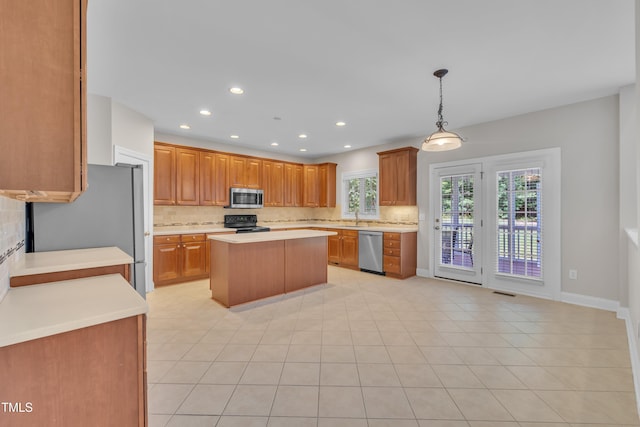 805 Alden Bridge Dr, Cary, NC 27519 - kitchen with stainless steel appliances, backsplash, light countertops, a kitchen island, and recessed lighting