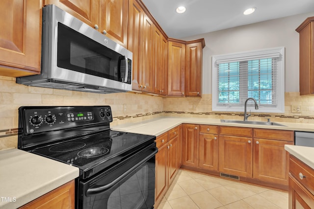 805 Alden Bridge Dr, Cary, NC 27519 - kitchen featuring black electric range oven, stainless steel microwave, a sink, light countertops, and backsplash