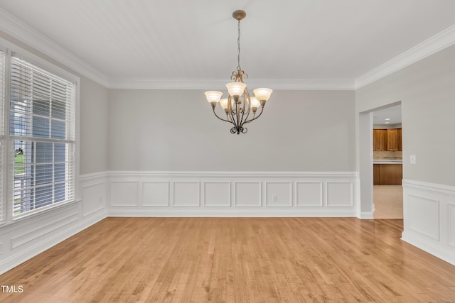 805 Alden Bridge Dr, Cary, NC 27519 - empty room with a chandelier, crown molding, light wood-type flooring, and a wainscoted wall