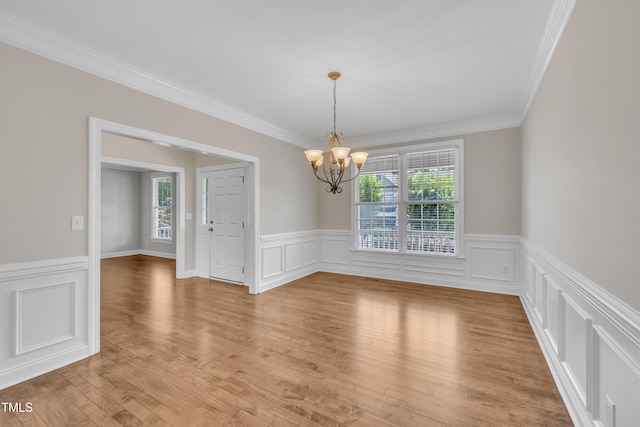 805 Alden Bridge Dr, Cary, NC 27519 - unfurnished room featuring a chandelier, a wainscoted wall, crown molding, light wood-type flooring, and a decorative wall