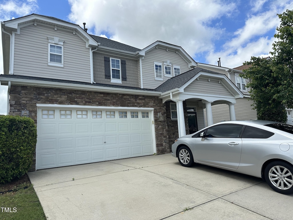 3124 Mackinac Island Ln, Raleigh, NC 27610 - view of front of home with a garage, concrete driveway, stone siding, and a shingled roof