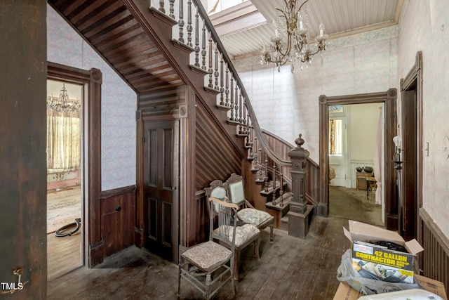 903 Nicholas St, Henderson, NC 27536 - stairs featuring a chandelier, wallpapered walls, a wainscoted wall, and hardwood / wood-style floors