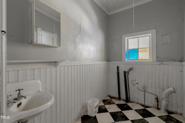 903 Nicholas St, Henderson, NC 27536 - bathroom with a wainscoted wall, tile patterned floors, a sink, and ornamental molding
