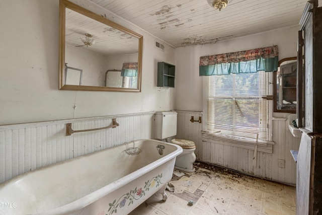 903 Nicholas St, Henderson, NC 27536 - full bath with a wainscoted wall, a freestanding tub, tile patterned floors, toilet, and wooden ceiling