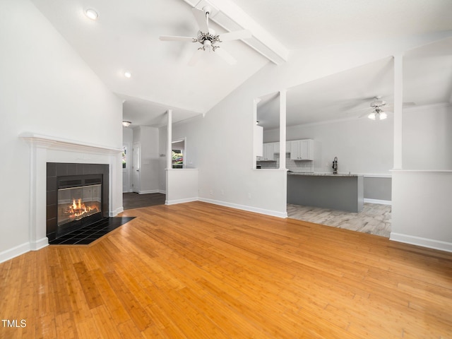 8312 Bellingham Cir, Raleigh, NC 27615 - unfurnished living room with a ceiling fan, a tile fireplace, light wood-style floors, baseboards, and recessed lighting