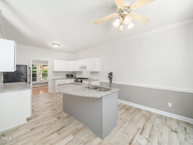 8312 Bellingham Cir, Raleigh, NC 27615 - kitchen with a sink, appliances with stainless steel finishes, light wood-style floors, white cabinetry, and ornamental molding