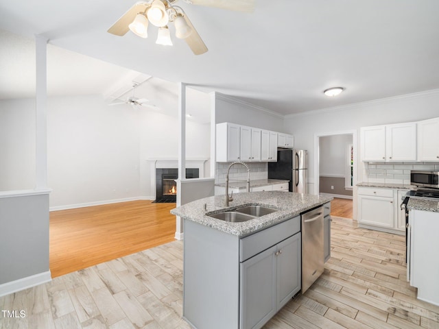8312 Bellingham Cir, Raleigh, NC 27615 - kitchen with a sink, appliances with stainless steel finishes, ceiling fan, tasteful backsplash, and light wood finished floors