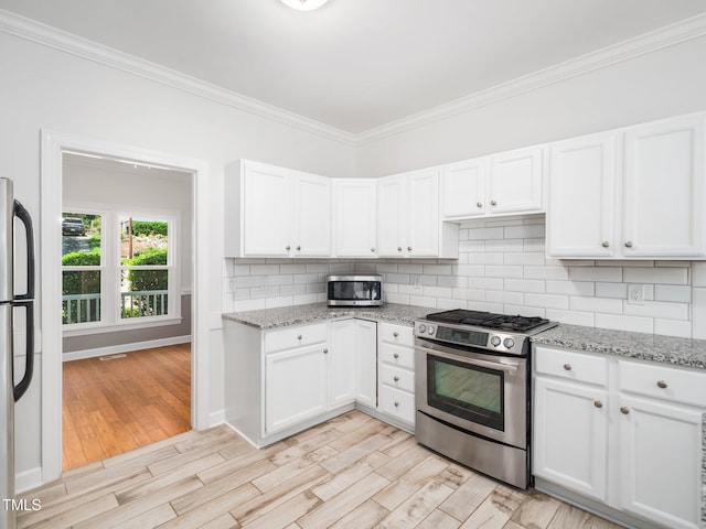 8312 Bellingham Cir, Raleigh, NC 27615 - kitchen featuring appliances with stainless steel finishes, crown molding, decorative backsplash, and white cabinetry