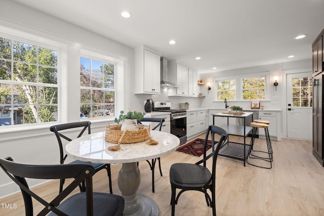 18 W Academy St, Wendell, NC 27591 - kitchen featuring stainless steel gas range, wall chimney range hood, plenty of natural light, light wood-type flooring, and recessed lighting