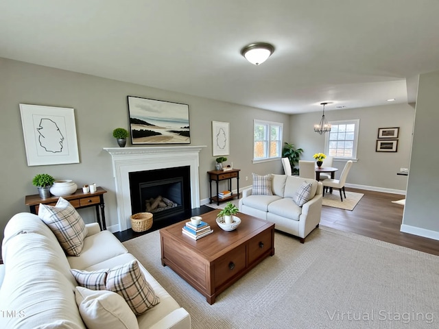 3804 Cobb St, Garner, NC 27529 - living room featuring light wood finished floors, a chandelier, baseboards, and a fireplace with flush hearth