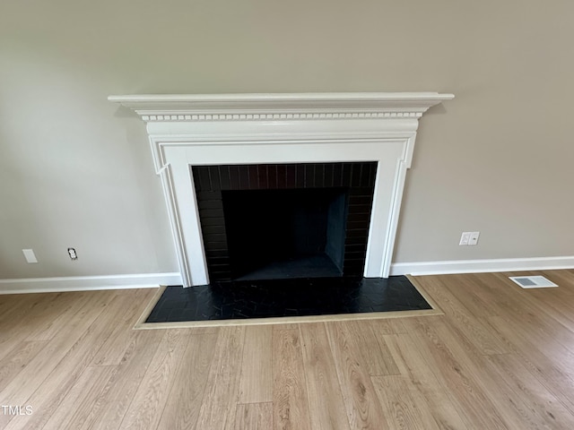 3804 Cobb St, Garner, NC 27529 - detailed view of baseboards, wood finished floors, and a brick fireplace