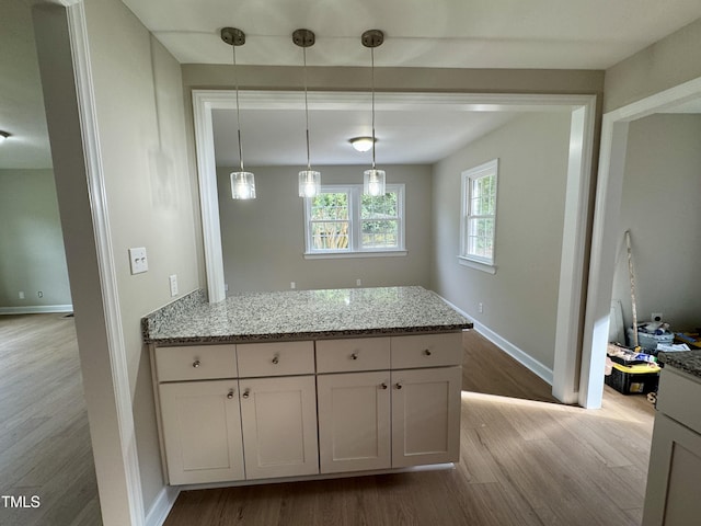 3804 Cobb St, Garner, NC 27529 - kitchen with wood finished floors, a peninsula, light stone countertops, and baseboards