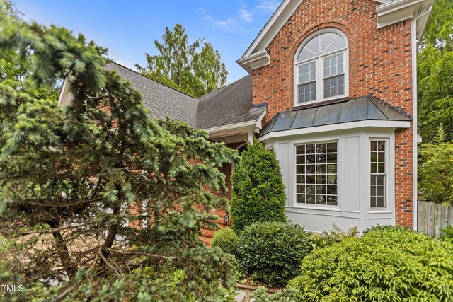 2001 Dobson Ct, Raleigh, NC 27612 - view of home's exterior with brick siding, a standing seam roof, and a shingled roof