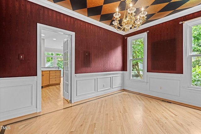 2001 Dobson Ct, Raleigh, NC 27612 - unfurnished dining area featuring a chandelier, light wood-style floors, crown molding, and a wainscoted wall