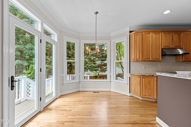 2001 Dobson Ct, Raleigh, NC 27612 - kitchen with under cabinet range hood, light wood-type flooring, ornamental molding, baseboards, and decorative backsplash
