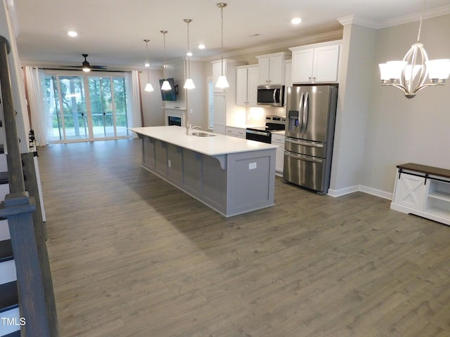 1311 Arena Ln, Fuquay Varina, NC 27526 - kitchen with appliances with stainless steel finishes, a chandelier, dark wood finished floors, white cabinets, and ornamental molding