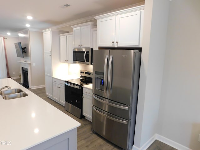 1311 Arena Ln, Fuquay Varina, NC 27526 - kitchen featuring stainless steel appliances, a sink, wood finished floors, white cabinets, and light countertops