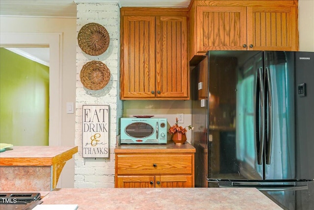 5625 Church Rd, Graham, NC 27253 - kitchen featuring freestanding refrigerator, ornamental molding, light countertops, and brown cabinets