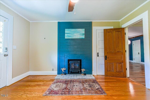 5625 Church Rd, Graham, NC 27253 - unfurnished living room with a wood stove, light wood-style flooring, ornamental molding, baseboards, and ceiling fan