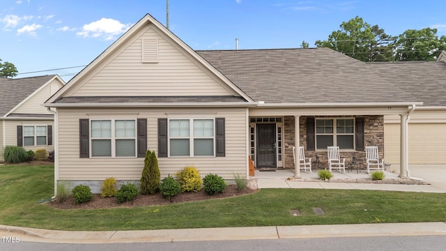 24 W Catalina Ct, Clayton, NC 27527 - view of front of house with a porch, a front lawn, a garage, and a shingled roof