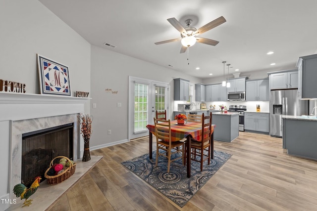 24 W Catalina Ct, Clayton, NC 27527 - dining area with a ceiling fan, light wood-style flooring, recessed lighting, a premium fireplace, and baseboards