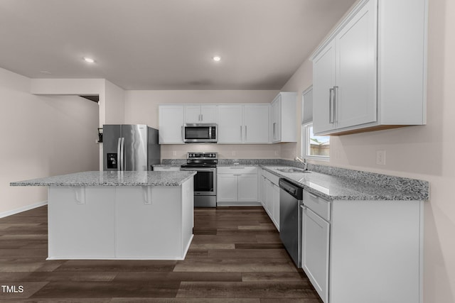 1401 Justice Union Ct, Raleigh, NC 27604 - kitchen with stainless steel appliances, a sink, a center island, white cabinetry, and light stone countertops