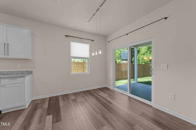 1401 Justice Union Ct, Raleigh, NC 27604 - unfurnished dining area with wood finished floors, rail lighting, and baseboards
