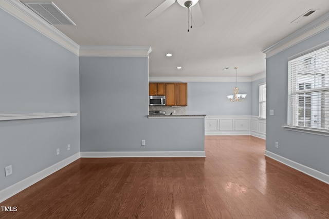 2082 Weston Green Loop, Cary, NC 27513 - kitchen featuring stainless steel microwave, brown cabinetry, crown molding, a chandelier, and wood finished floors