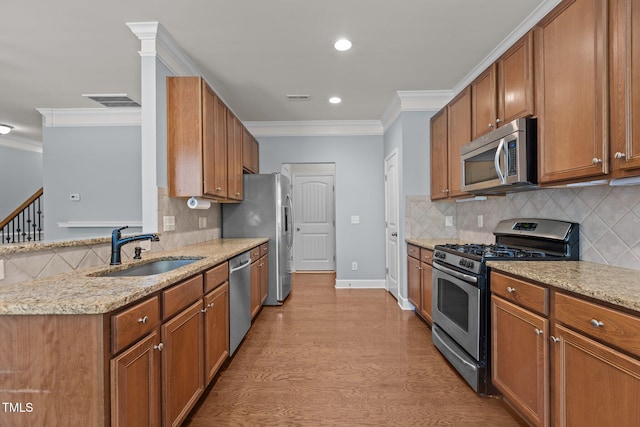 2082 Weston Green Loop, Cary, NC 27513 - kitchen featuring appliances with stainless steel finishes, a sink, ornamental molding, light stone countertops, and backsplash