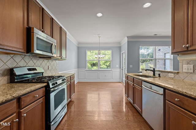 2082 Weston Green Loop, Cary, NC 27513 - kitchen with appliances with stainless steel finishes, a sink, ornamental molding, a chandelier, and wainscoting