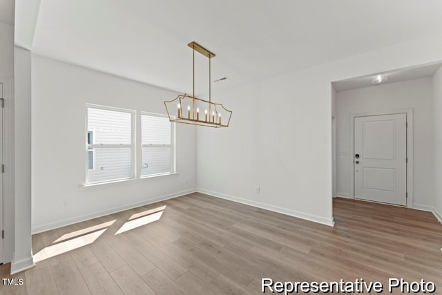 56 Mable Ct Unit 20, Lillington, NC 27546 - unfurnished dining area featuring a chandelier, light wood finished floors, and baseboards