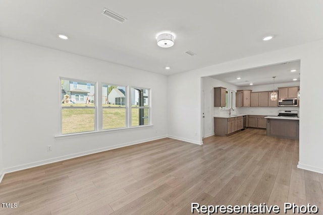 56 Mable Ct Unit 20, Lillington, NC 27546 - unfurnished living room featuring light wood-type flooring, a sink, recessed lighting, and baseboards
