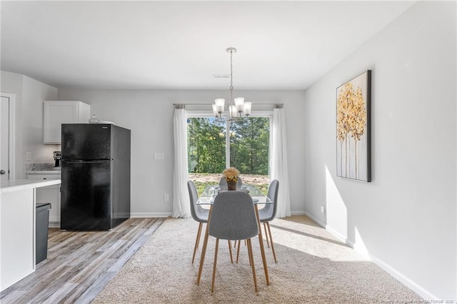 905 Sapphire Stone Ln, Hope Mills, NC 28348 - dining area with a chandelier, light wood-style floors, and baseboards