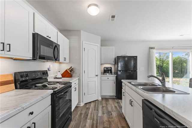 905 Sapphire Stone Ln, Hope Mills, NC 28348 - kitchen with black appliances, a sink, dark wood finished floors, and white cabinetry